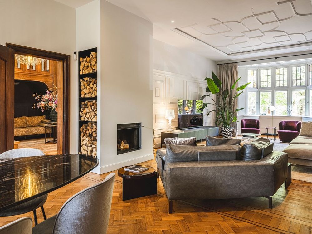 Stijlvolle woonkamer van Heemraadssingel 109 met een warme sfeer, luxe haard en grote ramen met uitzicht op de singel.