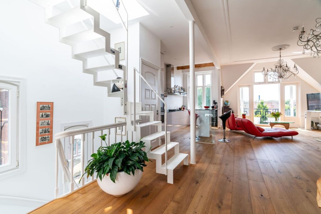 Een lichte en ruime woonkamer met prachtig hoge plafonds en stijlvolle afwerking. De open indeling en het moderne design creëren een gevoel van luxe en comfort, perfect voor ontspanning en genieten van het uitzicht.