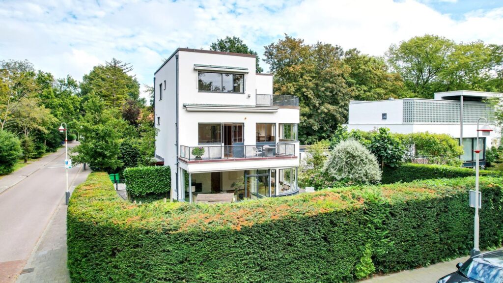 Een moderne villa met strakke lijnen en grote raampartijen, omringd door groen. Rust en luxe in een van de mooiste wijken van Den Haag.