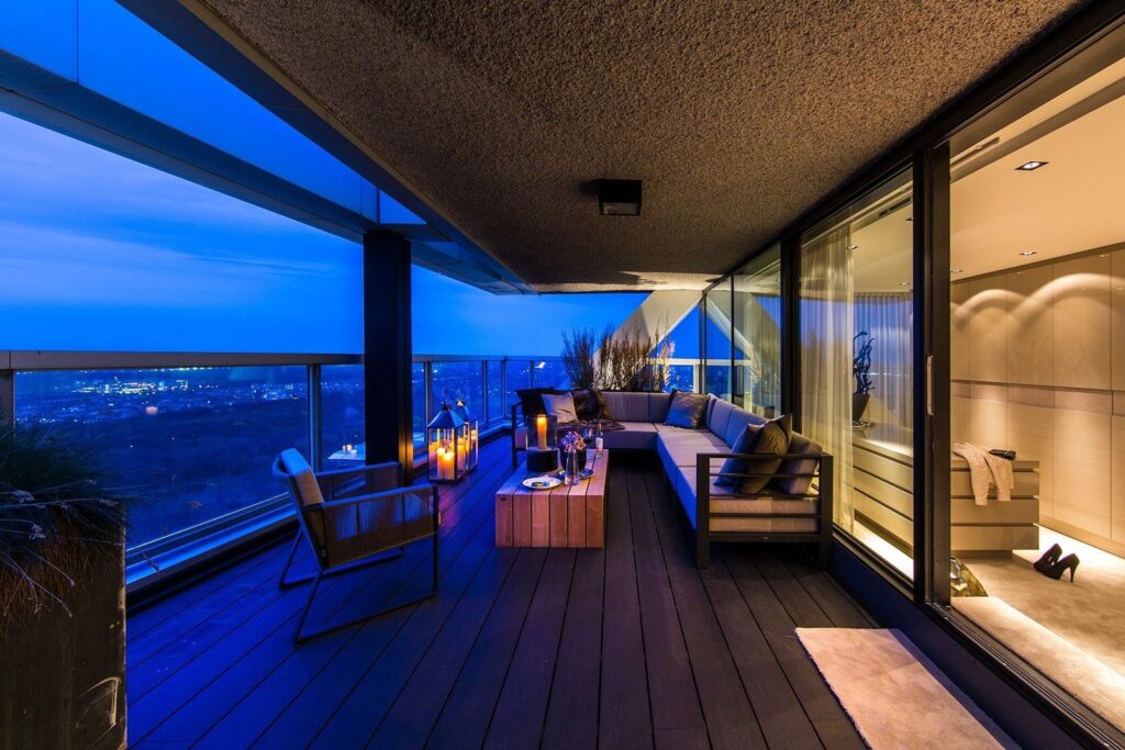 Een stijlvol en sfeervol terras met panoramisch uitzicht over de stad. De ideale plek om te ontspannen bij zonsondergang, omringd door luxe en comfort.