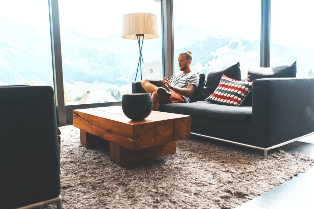 Man ontspant in moderne woonkamer op een comfortabele bank met een perfect gekozen vloerkleed voor een stijlvolle en gezellige sfeer.