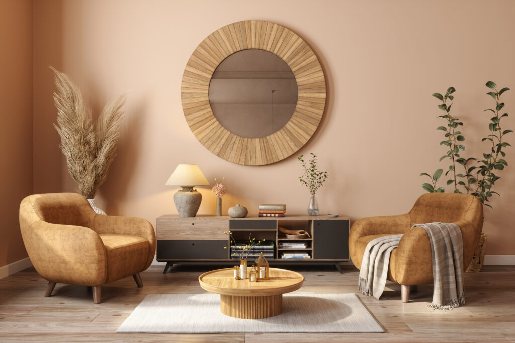 Moderne woonkamer met een grote ronde spiegel die de ruimte ruimtelijker laat aanvoelen, beige stoelen, houten salontafel, en natuurlijke decoraties.