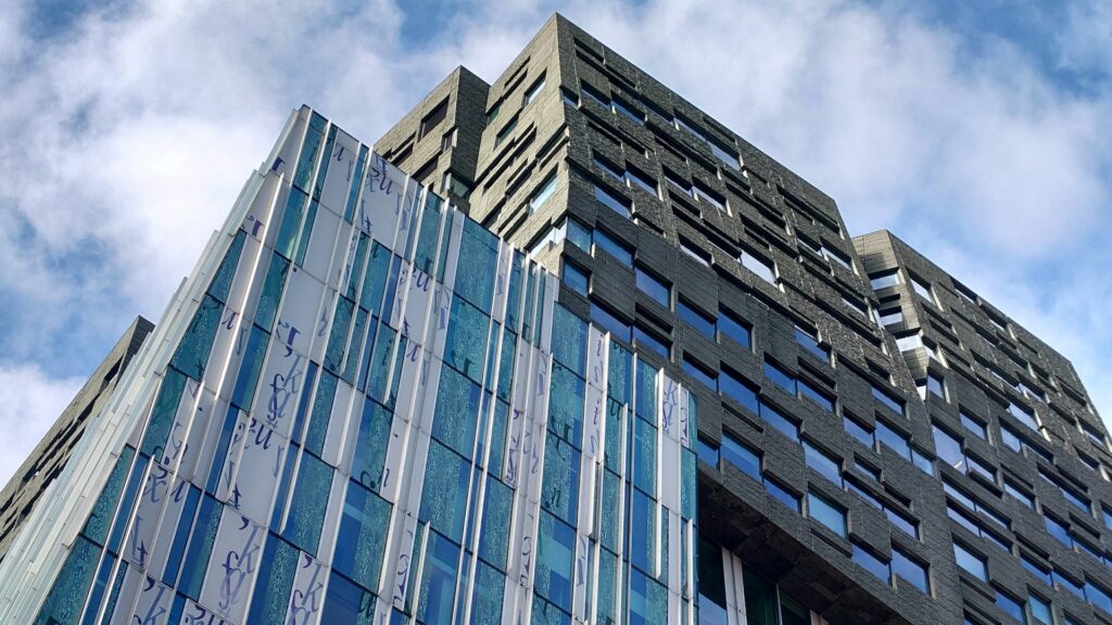 Modern kantoorgebouw met glas- en baksteenstructuur aan de Zuidas, symbool voor vastgoedfondsen