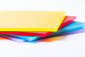 Verschillende gekleurde plexiglasplaten gestapeld, perfect voor veelzijdige toepassingen in interieurdesign en decoratie.