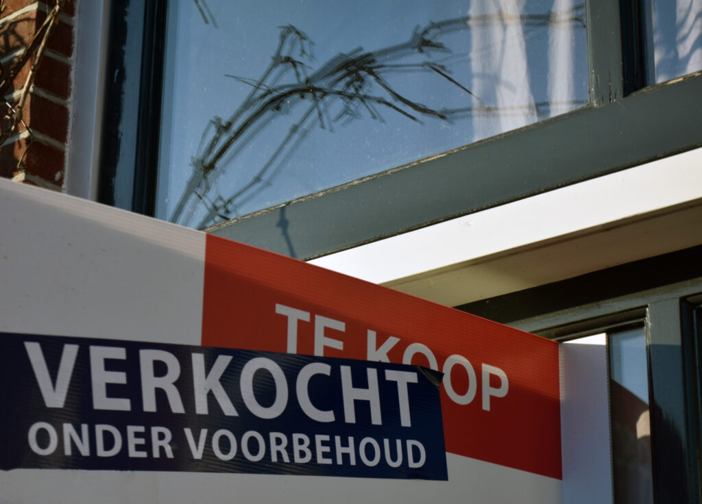 Te koop bord met 'Verkocht onder voorbehoud' op de woningmarkt, symbool voor stijgende huizenprijzen en de uitdagingen van kopers in 2025.