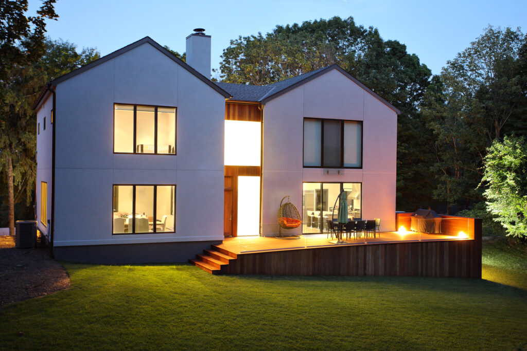 Moderne woning met functionele en sfeervolle tuinverlichting die de buitenruimte en terras verlichten, met een warme uitstraling in de avond.
