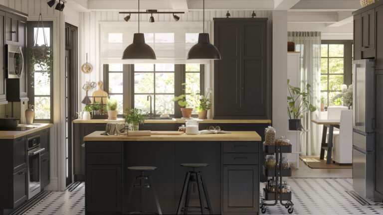 Moderne zwarte IKEA-keuken met houten blad, planten en natuurlijk daglicht