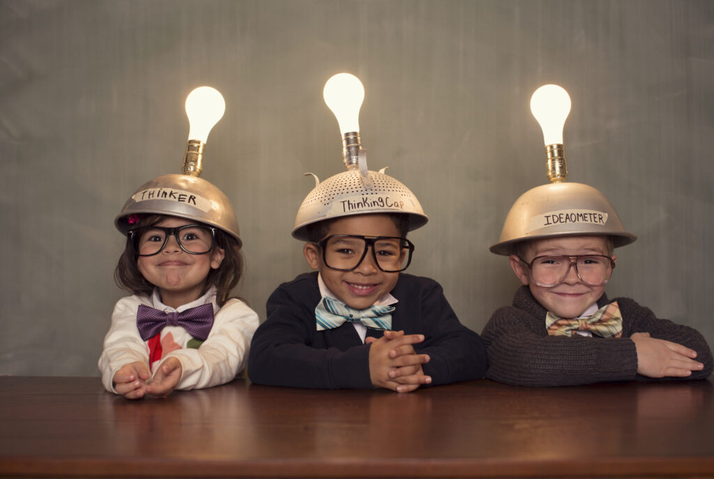 Kinderen met creatieve helmen en gloeilampen, symbool voor slimme en energiezuinige ideeën in huis