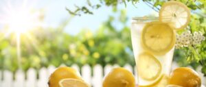 Verfrissend glas citroenlimonade in een zomerse tuin vol zon en groen