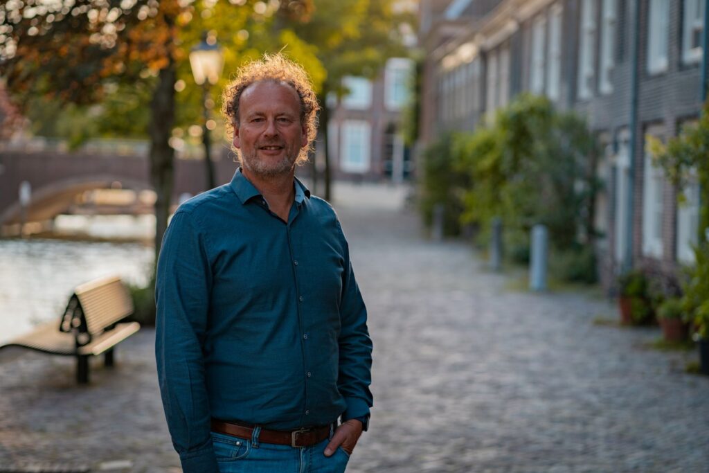 Ronald Barends van Huislijn.nl in historische straat met woningen op achtergrond