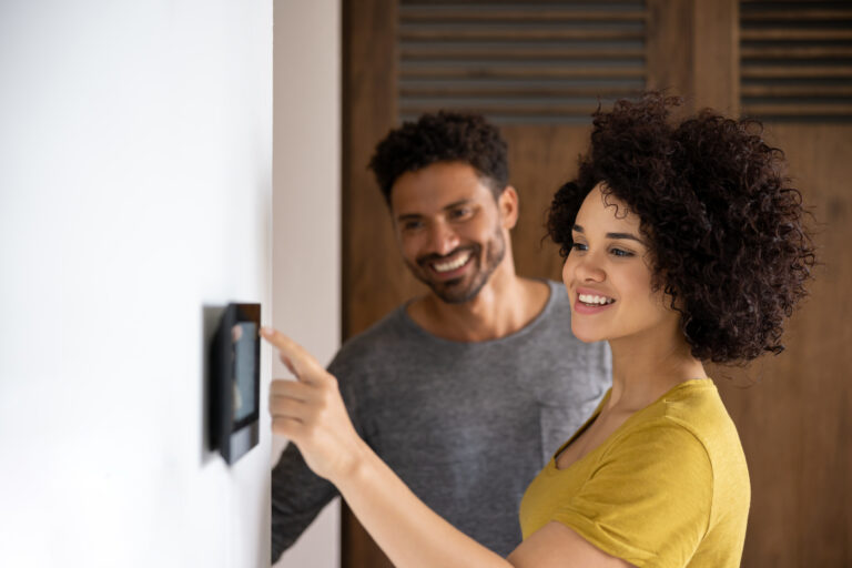 Stel bedient smart home beveiligingssysteem samen in moderne woning