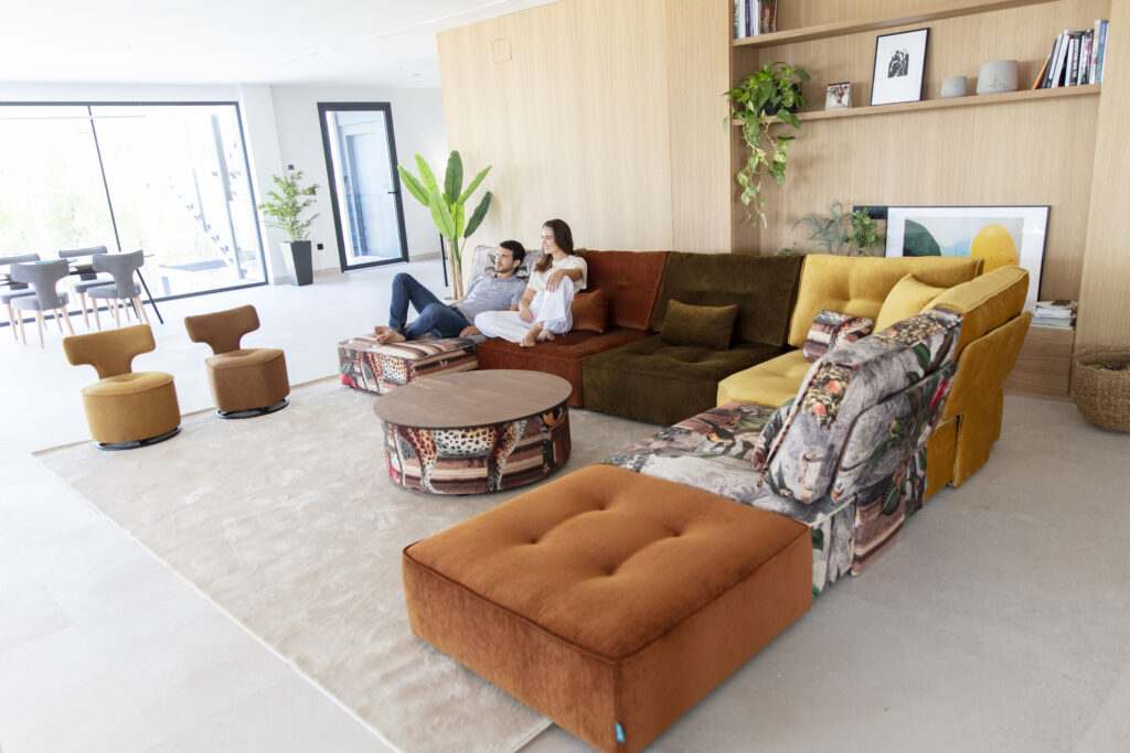 Kleurrijke modulaire designbank van Fama in een lichte woonkamer met een ontspannen stel.