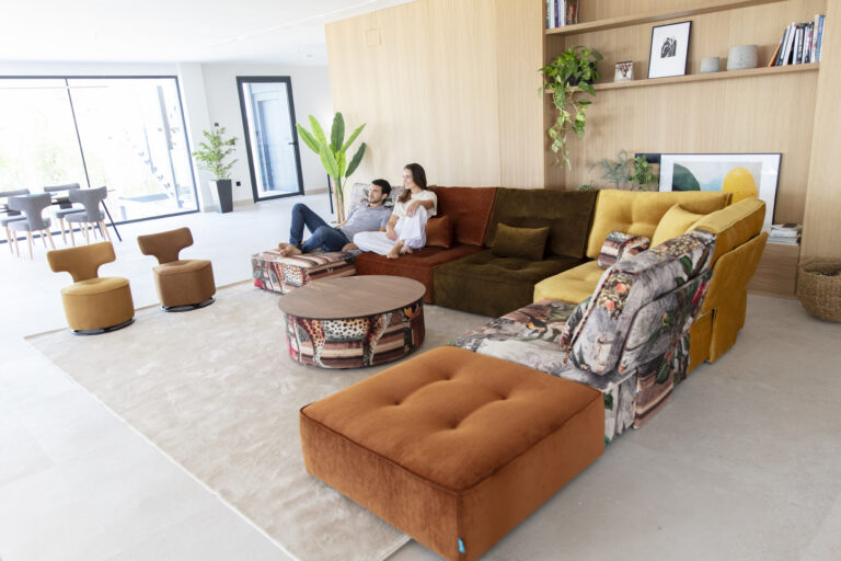 Kleurrijke modulaire designbank van Fama in een lichte woonkamer met een ontspannen stel.