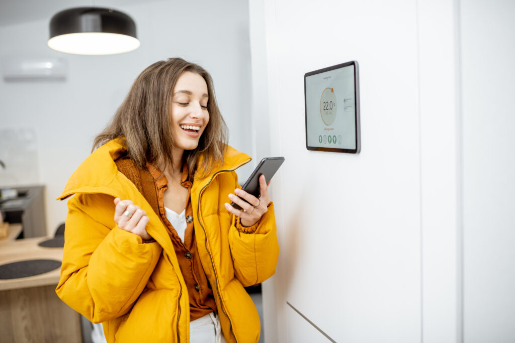 Vrouw stelt slimme thermostaat in via smartphone om energie te besparen
