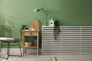 Moderne woonkamer met groene muur en strakke radiatorombouw die naadloos opgaat in het interieur.
