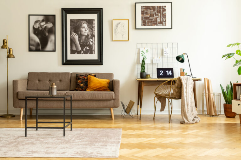 Woonkamer met bank, persoonlijke foto’s aan de muur en warme accenten in een bewoond interieur