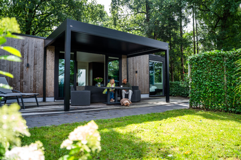 stel zit op terras van een vakantiewoning op een vakantiepark in een groene omgeving