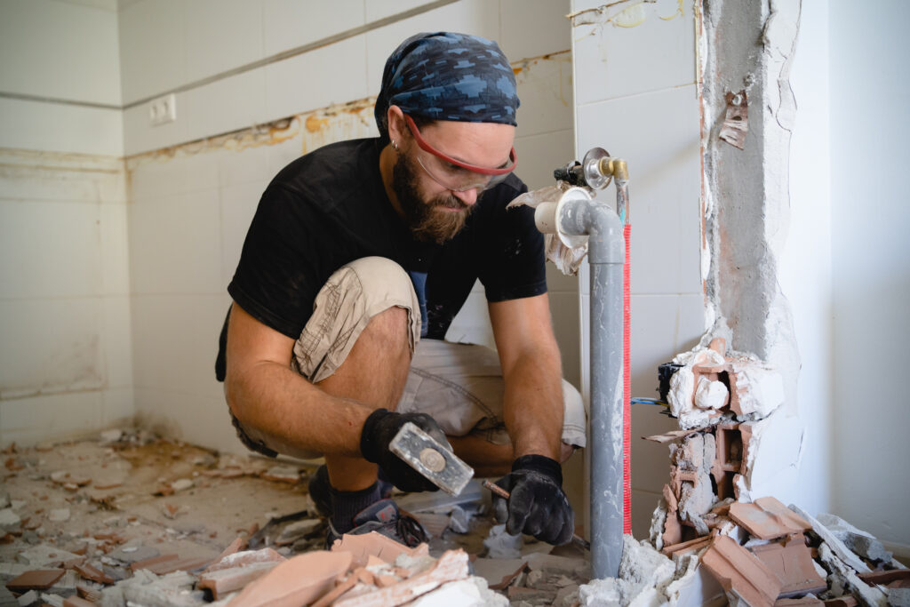 Badkamer renovatie met zichtbaar leidingwerk en sloopwerk tijdens verbouwing