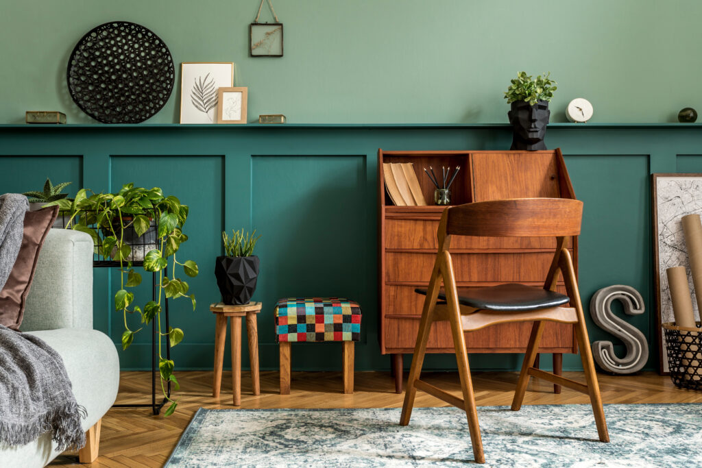 Interieur met groene wand, houten meubels, planten en woonaccessoires in één duidelijke stijl