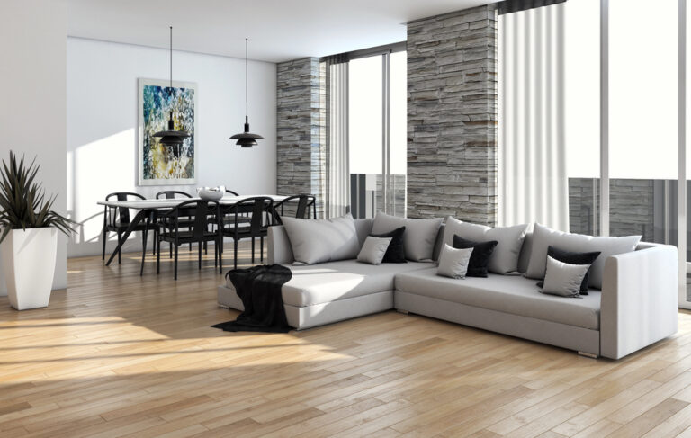 Moderne woonkamer met een lichte houtlook vloer en grijze hoekbank