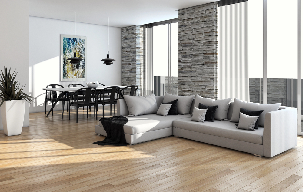 Moderne woonkamer met een lichte houtlook vloer en grijze hoekbank